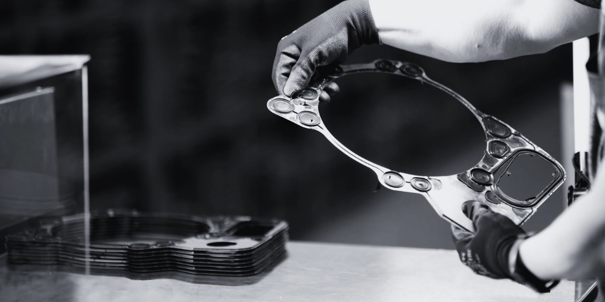 Hands holding a large metal gasket